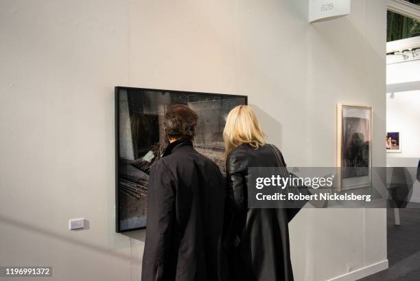 Two people attending the annual Paris Photo photography art fair look at a photograph at the Grand Palais in Paris, France on November 6, 2019. Paris...