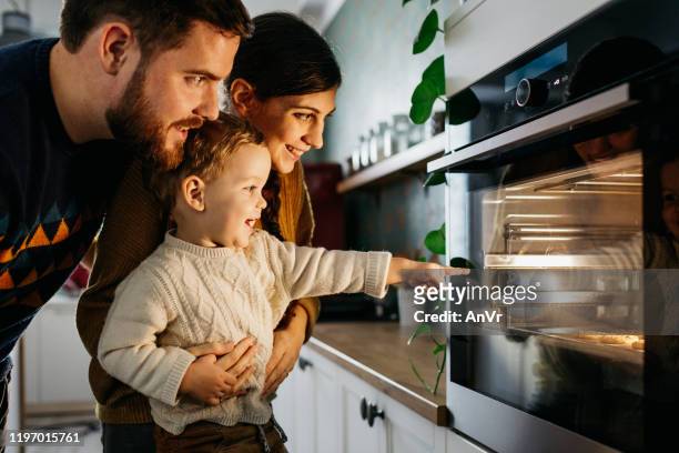 il ragazzo sta indicando l'owen - famiglia cucina foto e immagini stock