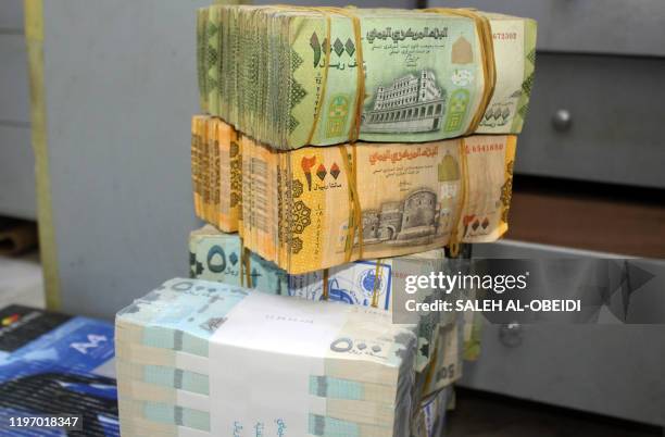 Old and new Yemeni bank notes are pictured at a money exchange office in the southern port city of Aden on January 23, 2020. - A flare-up in a local...