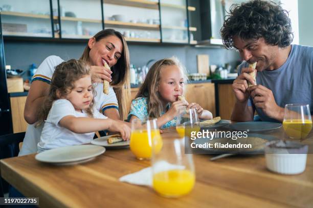 family enjoying breakfast - drinking juice stock pictures, royalty-free photos & images