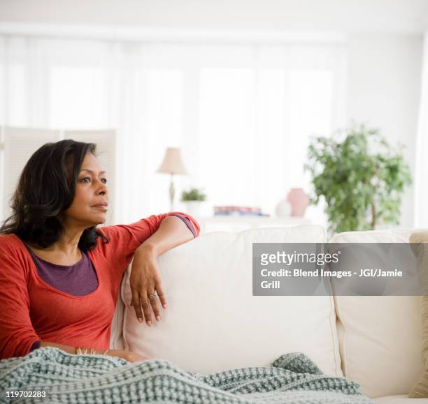 mixed race woman laying on sofa - pensive bildbanksfoton och bilder
