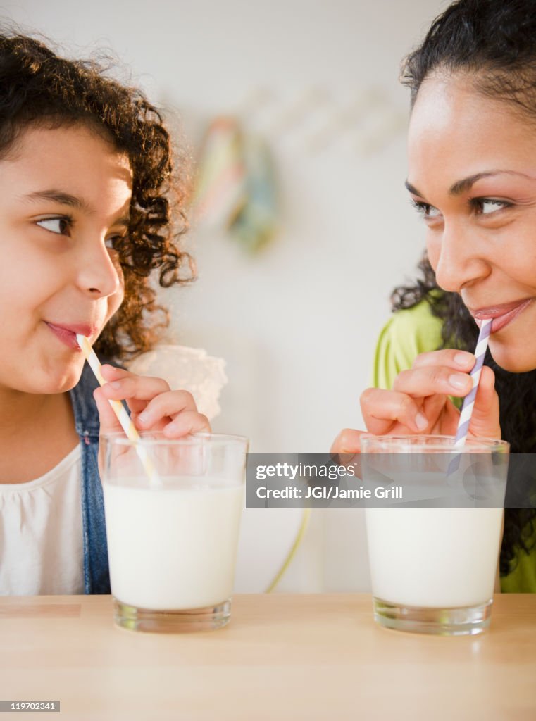 Mother and daughter drinking milk with straws