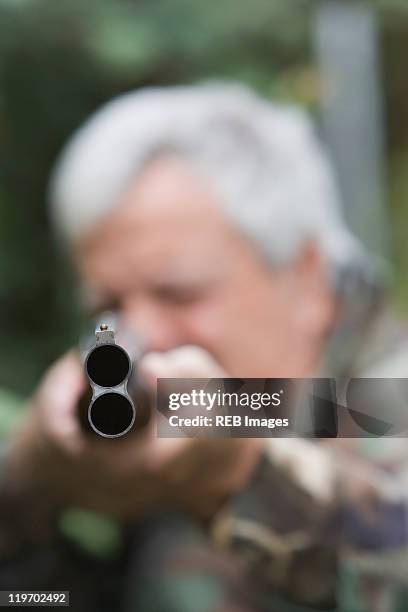 senior chilean man pointing shotgun - shotgun stockfoto's en -beelden