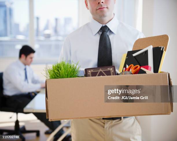 fired caucasian businessman carrying personal belongings - rechazar fotografías e imágenes de stock