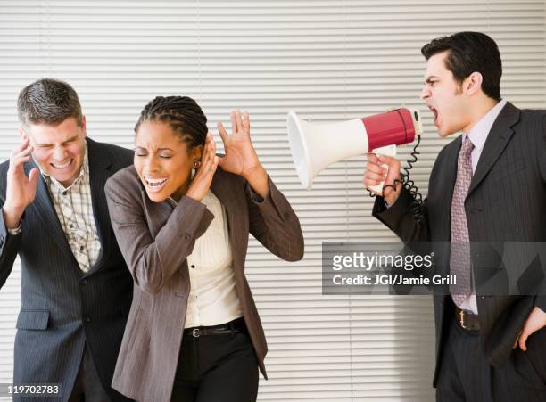 businessman shouting through bullhorn at co-workers - workplace bullying stock pictures, royalty-free photos & images