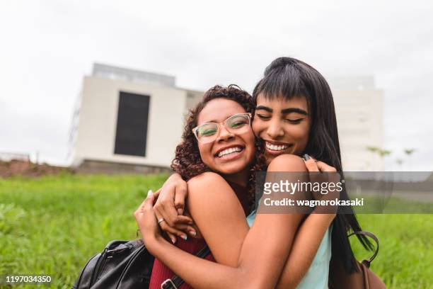 middelbare scholieren vieren en knuffelen elkaar - pardo stockfoto's en -beelden