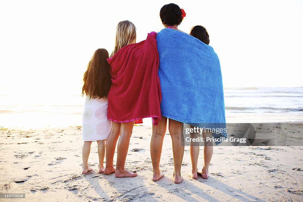 Girls wrapped in towels standing on beach