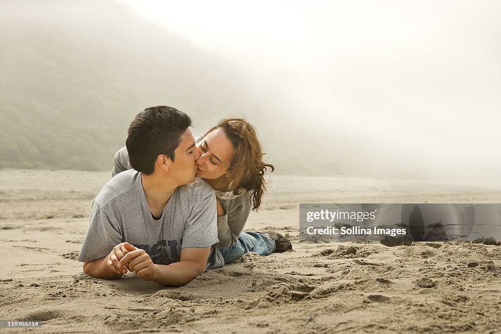 Hispanic couple kissing on beach