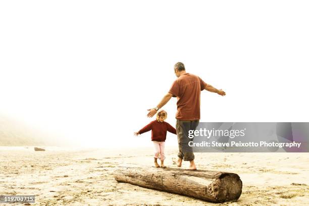 father and daughter balancing on log - santa cruz california beach stock pictures, royalty-free photos & images