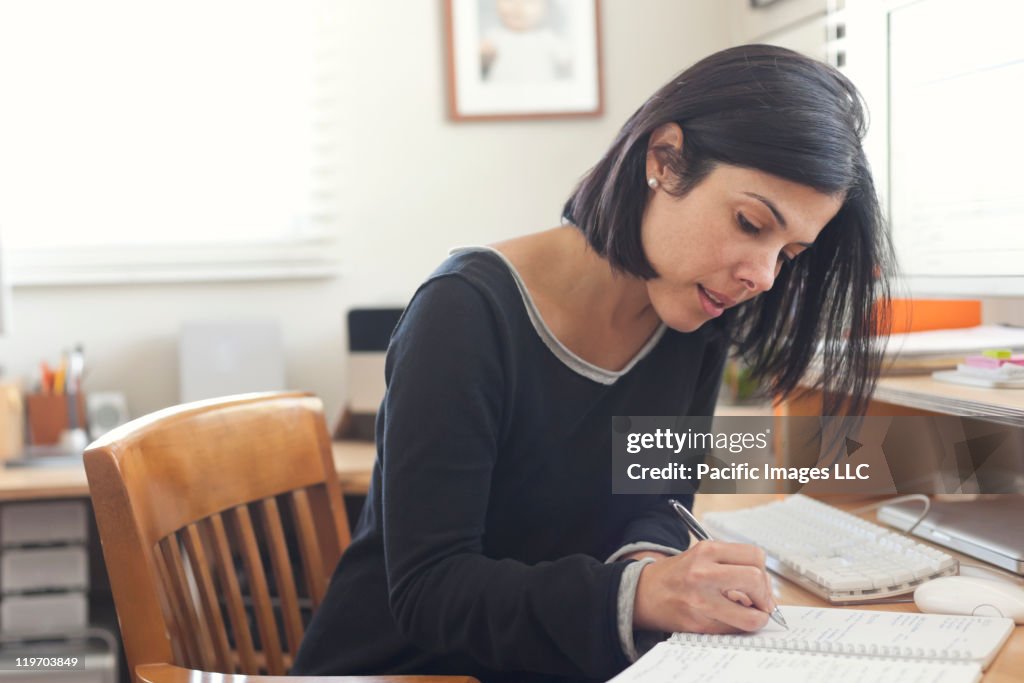 Hispanic woman working in home office