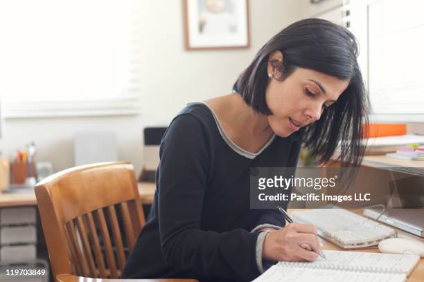 hispanic woman working in home office - writing stock pictures, royalty-free photos & images