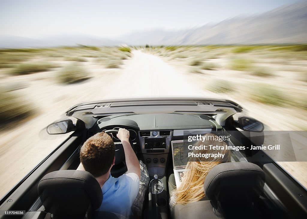 USA, California, Palm Springs, Coachella Valley, San Gorgonio Pass, Couple driving through desert in convertible car