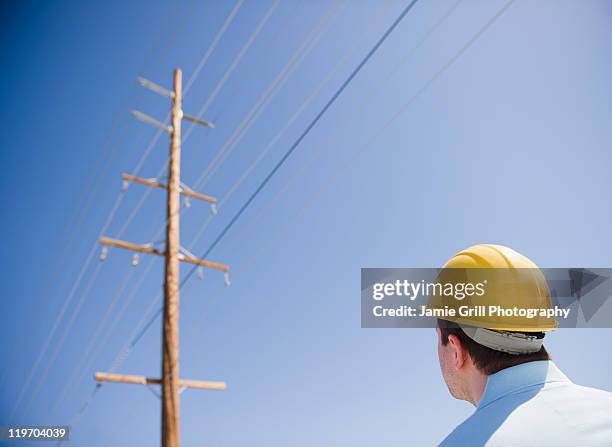 usa, california, palm springs, coachella valley, san gorgonio pass, man in hard hat looking at telephone pole - coachella outfit stock pictures, royalty-free photos & images