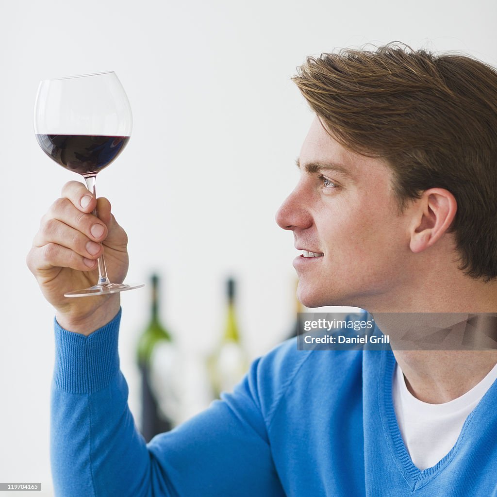 USA, New Jersey, Jersey City, young man examining red wine