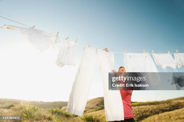 usa, california, ladera ranch, woman hanging laundry on clothesline - clothesline stock pictures, royalty-free photos & images