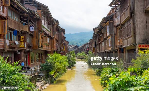 river flowing through a dong village in the mountain, zhaoxing, guizhou province, china - asia village river stock pictures, royalty-free photos & images