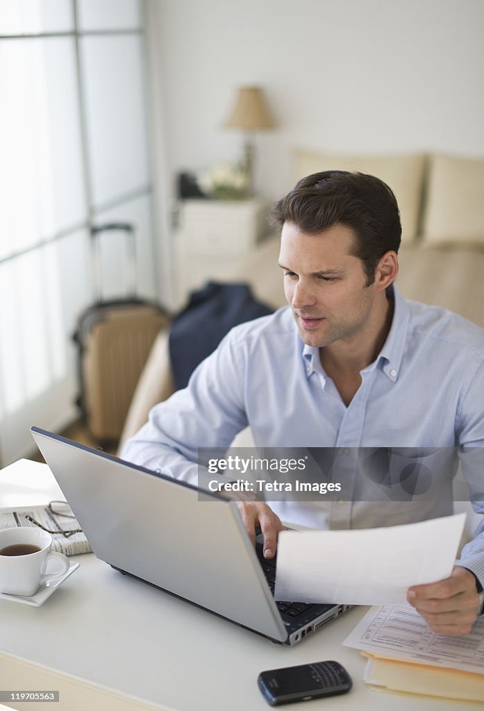 USA, New Jersey, Jersey City, man using laptop at home office