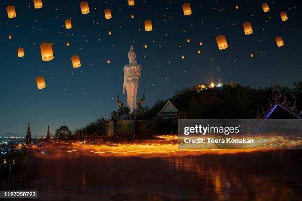 makha bucha day, candle lit from buddhists are moving around buddha statue at chonburi - yi peng stock pictures, royalty-free photos & images