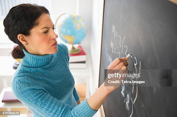 usa, new jersey, jersey city, mature woman writing on blackboard - tetra images teacher stock pictures, royalty-free photos & images