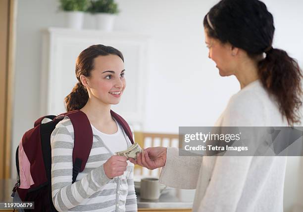 usa, new jersey, jersey city, mother giving money to teenage daughter (14-15) - pocket money stock pictures, royalty-free photos & images