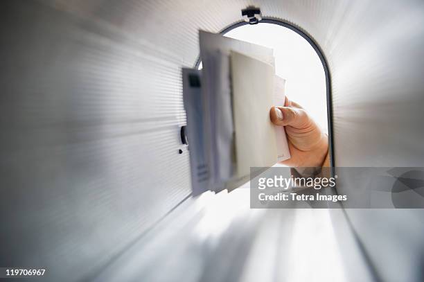 close-up of man's hand removing letters from letter box - brievenbus stockfoto's en -beelden