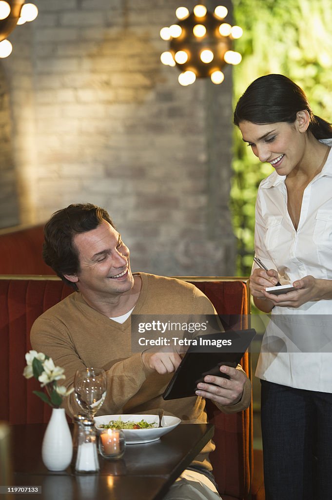 USA, New York, New York City, Man ordering food in restaurant