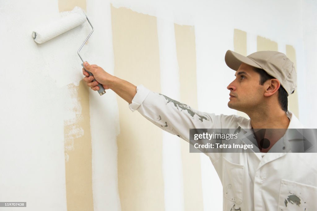 USA, New Jersey, Jersey City, man painting wall white