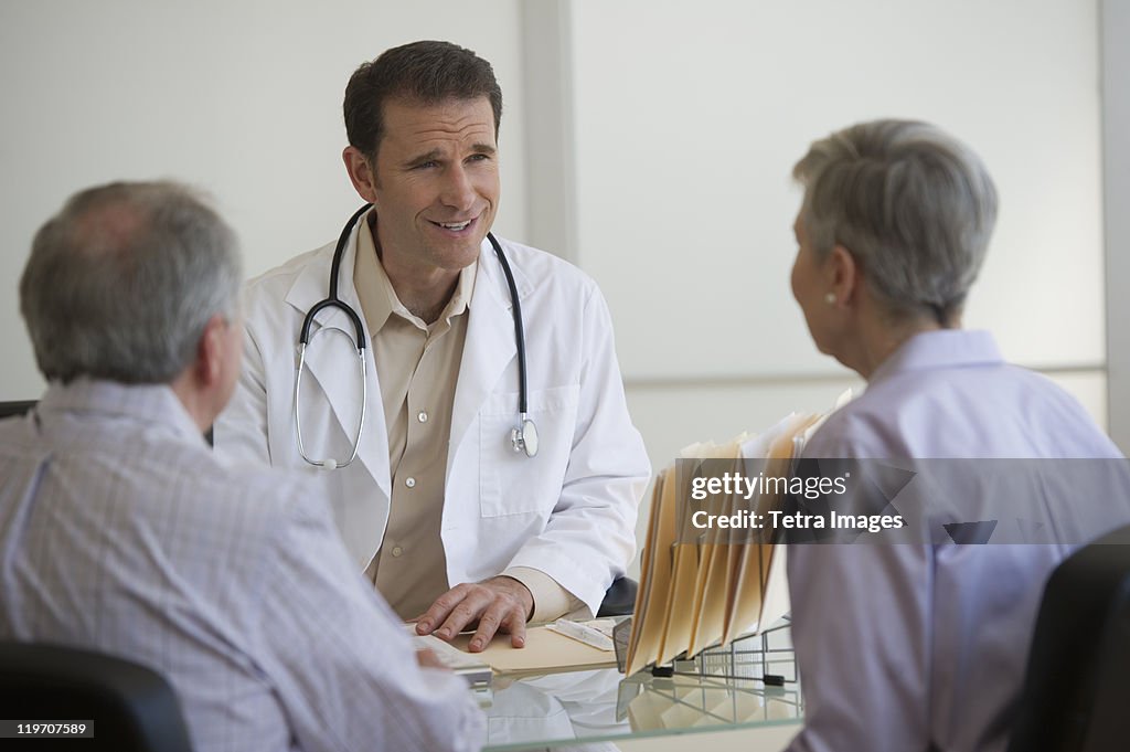 USA, New Jersey, Jersey City, Doctor and senior couple talking in office