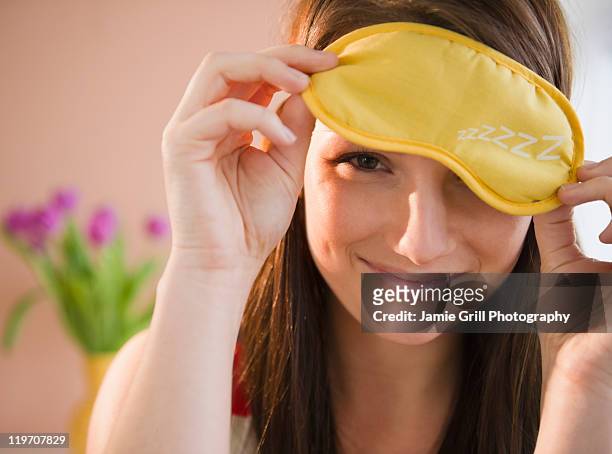 usa, new jersey, jersey city, young woman holding yellow sleep mask - masque pour les yeux photos et images de collection