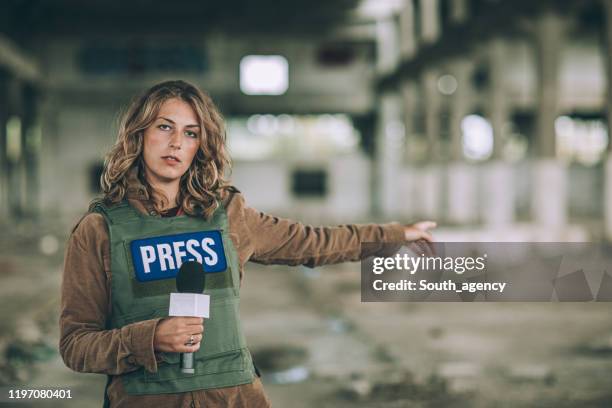 mujer reportando desde la zona de guerra - periodista de televisión fotografías e imágenes de stock
