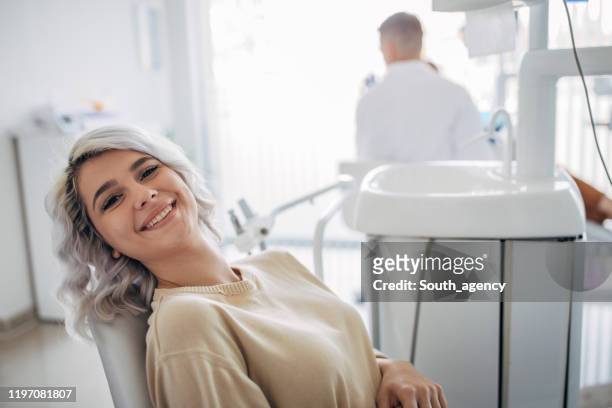 dentist patient showing perfect smile after treatment - dentist's chair stock pictures, royalty-free photos & images