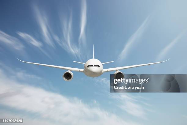 front view of passenger airplane flying above clouds - vorderansicht stock-fotos und bilder