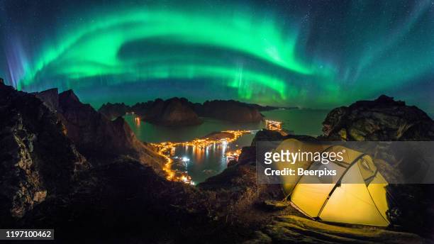 camping on the reinebringen with the northern lights over reine, lofoten islands, norway. - southern lights stock pictures, royalty-free photos & images