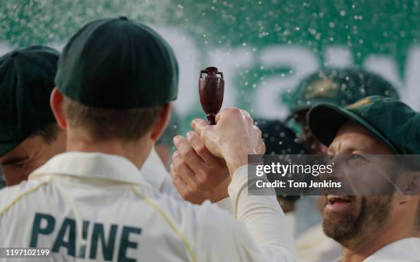 Australian captain Tim Paine shows off the Ashes urn to his teammates at the presentation ceremony after the match during day four of the England v...