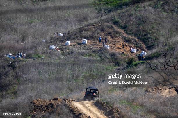 Investigators work at the scene of the helicopter crash, where former NBA star Kobe Bryant and his 13-year-old daughter Gianna died, on January 28,...