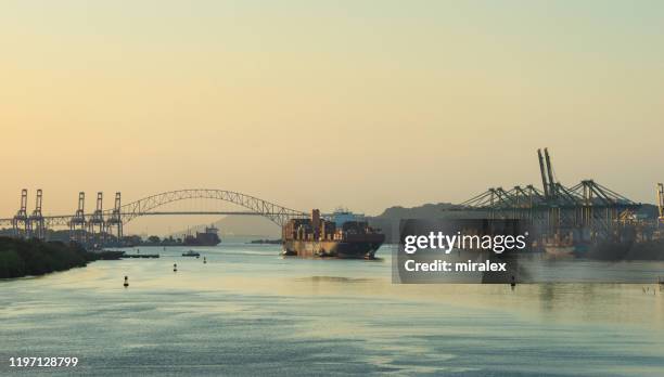 container ship enters panama canal at dawn - bridge of the americas stock pictures, royalty-free photos & images