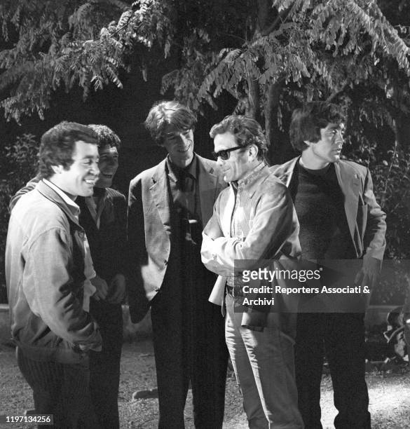 Italian writer and director Pier Paolo Pasolini standing with Italian actors Franco Citti and Ninetto Davoli and French actor Laurent Terzieff on the...
