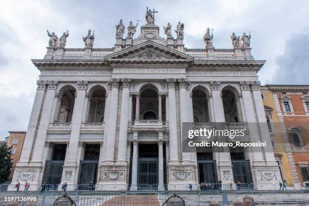 people walking next to the archbasilica of saint john lateran at rome city, italy. - basílica de são joão de latrão imagens e fotografias de stock