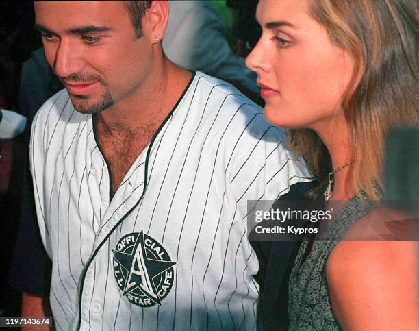 American tennis player Andre Agassi with his partner, actress Brooke Shields, circa 1997. Agassi is wearing an Official All Star Cafe shirt.