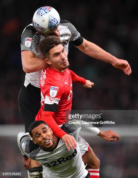 Kieffer Moore of Barnsley competes for a header with Matthew Clarke and Max Lowe of Derby County during the Sky Bet Championship match between Derby...