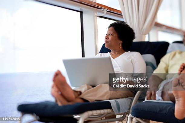 woman on lounge chair with laptop - time off work stock pictures, royalty-free photos & images