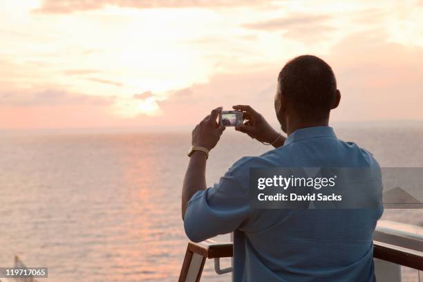 man taking picture of sunset - camera boat stock pictures, royalty-free photos & images