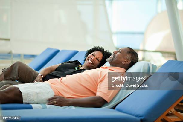 mature couple on lounge chair on cruise ship - クルージング ストックフォトと画像