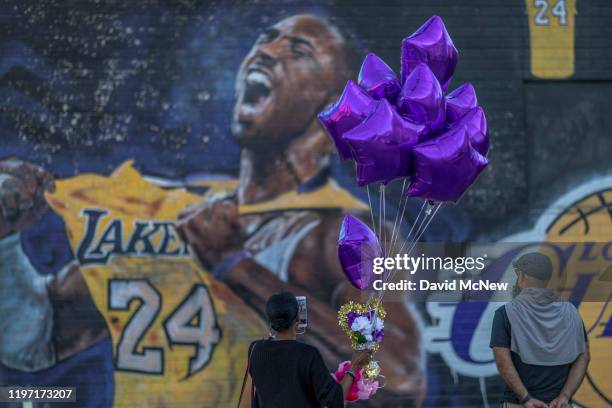 Fans visit a mural of former NBA star Kobe Bryant who, along with his 13-year-old daughter Gianna, died January 26 in a helicopter crash, on January...