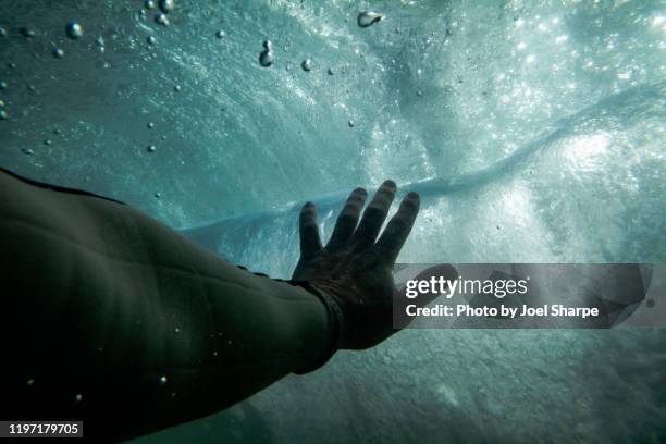 hand reaching towards water surface - ahogarse fotografías e imágenes de stock