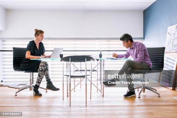 woman and man architects working together in their office - paarse schoen stockfoto's en -beelden