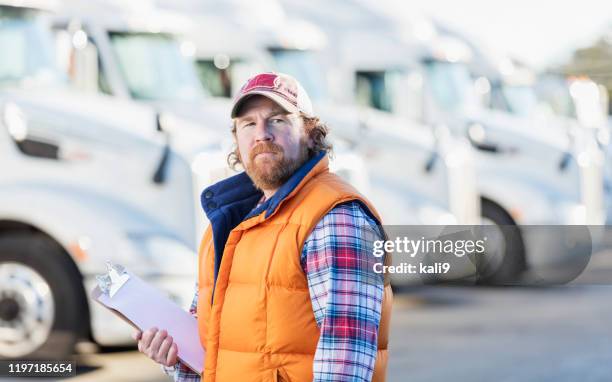 man standing in front of semi-truck fleet - fleet manager stock pictures, royalty-free photos & images