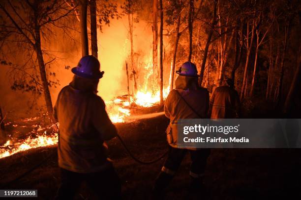 Firefighters work through the night to prevent a flare-up from crossing the Kings Highway in between Nelligen and Batemans Bay on January 2, 2020 in...