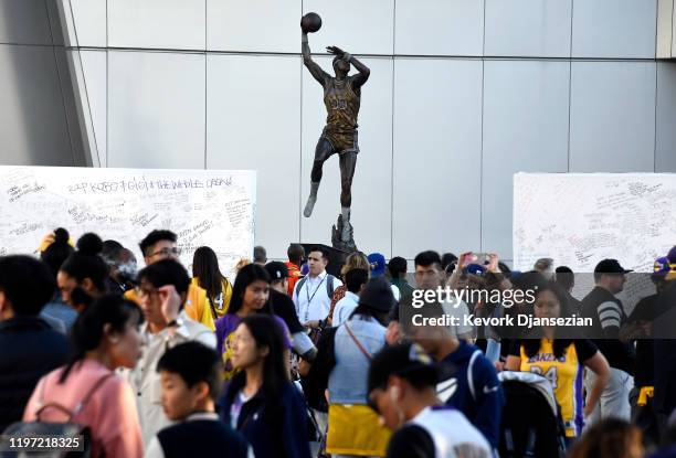 Fans continue to pay their respects to Kobe Bryant and his daughter Gianna at a memorial set up near Kareem Abdul Jabbar statue outside of Staples...