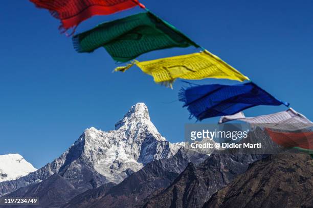 tibetan buddhism prayer flags flying above the ama dablam peak in nepal - tibetano fotografías e imágenes de stock